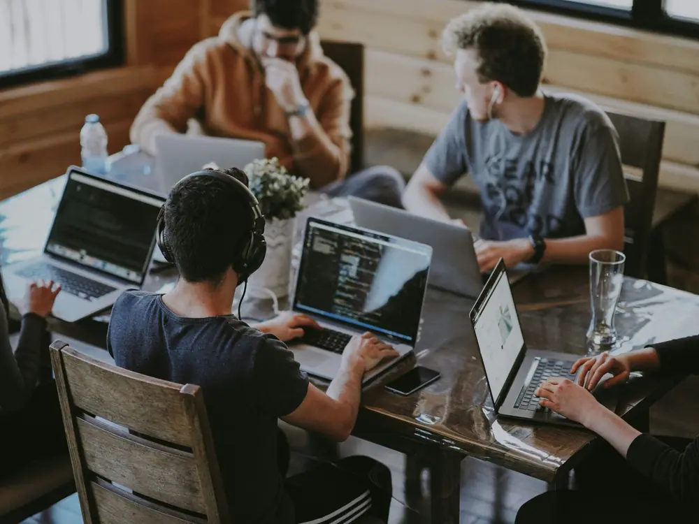 Beberapa orang bekerja dengan laptop di satu meja