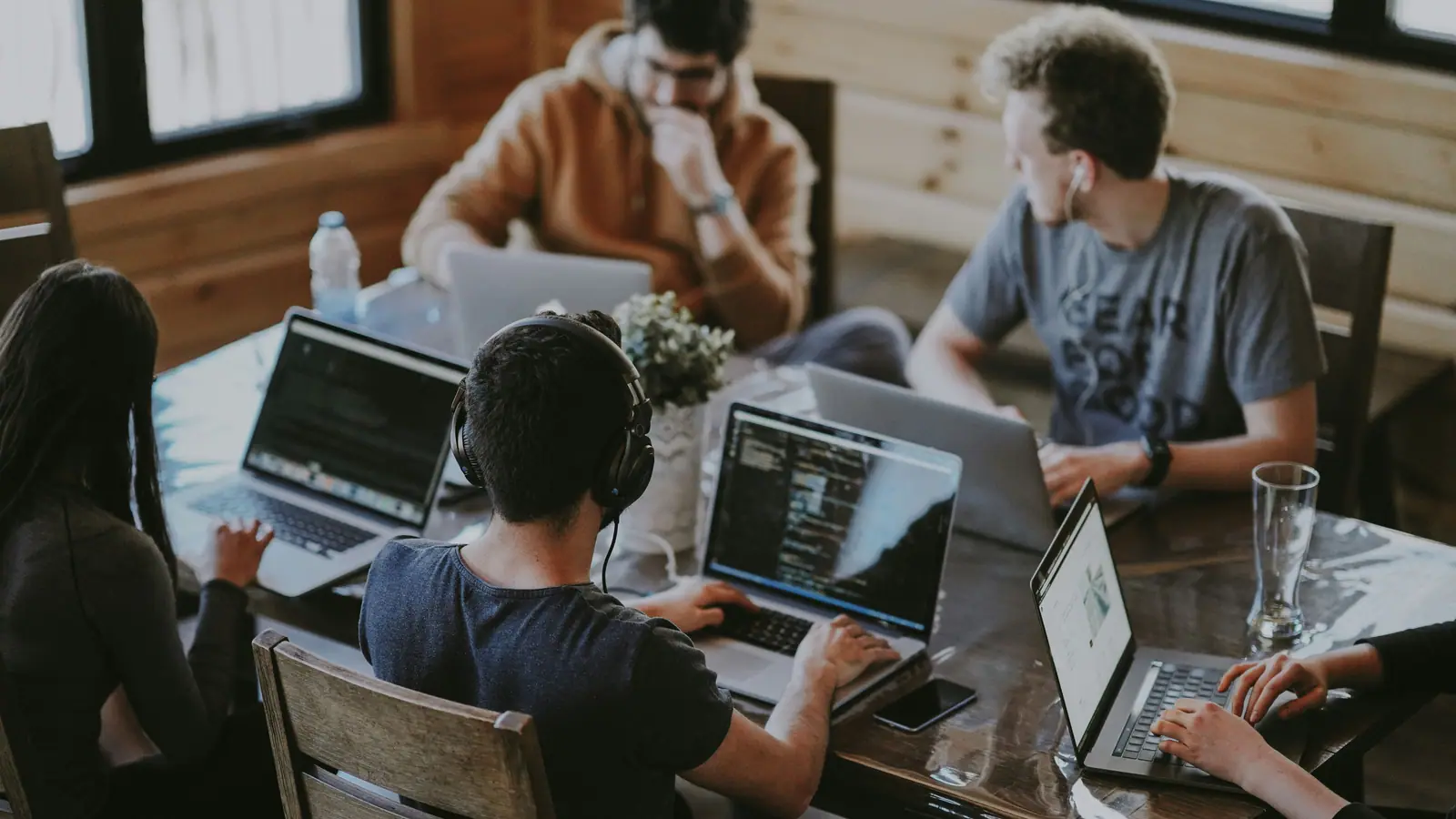 Beberapa orang mengerjakan pekerjaan freelance digital dengan laptop